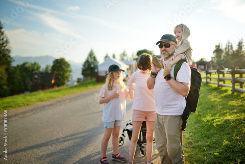 Family of three having fun on a walk on Gubalowka mountain range. High Tatra mountains and green hills in summer or spring.