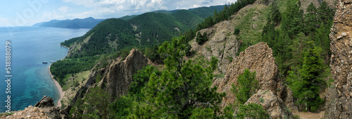 Summer view above from cliff to lake Baikal on sunny day. Beautiful panoramic landscape with clouds