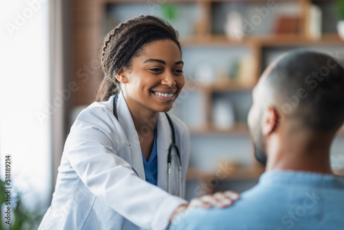 Canvastavla Cheerful african american woman doctor touching male patient shoulder