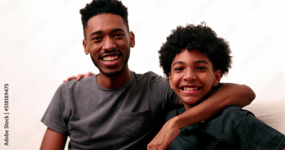 Obraz premium Two brothers together smiling. Black mixed race siblings, older and younger brother