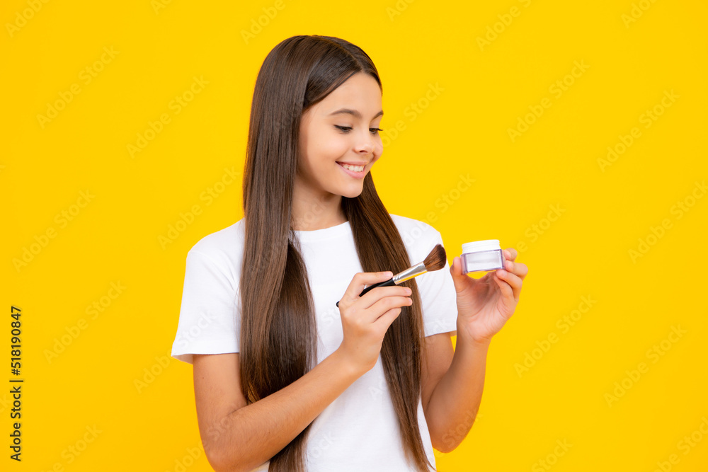 Teenage girl making beauty make up, hold powder and brush. Beautiful teen applying makeup using powder brush isolated on yellow background. Happy teenager portrait. Smiling girl. Teenage girl making beauty make up, hold powder and brush. Beautiful teen applying makeup using powder brush isolated on yellow background. Happy teenager portrait. Smiling girl.