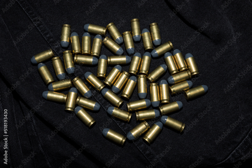 Many .45 ACP cartridges on a black fabric background Many .45 ACP cartridges on a black fabric background