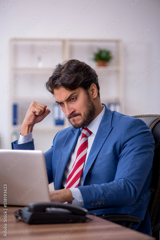 Young male employee and too much work in the office Young male employee and too much work in the office