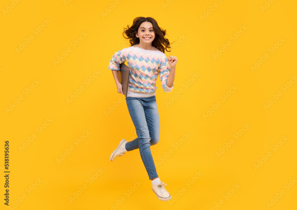 Young girl student hold computer. Funny pupil with laptop isolated on yellow background. Run and jump, jumping kids. Back to school. Young girl student hold computer. Funny pupil with laptop isolated on yellow background. Run and jump, jumping kids. Back to school.