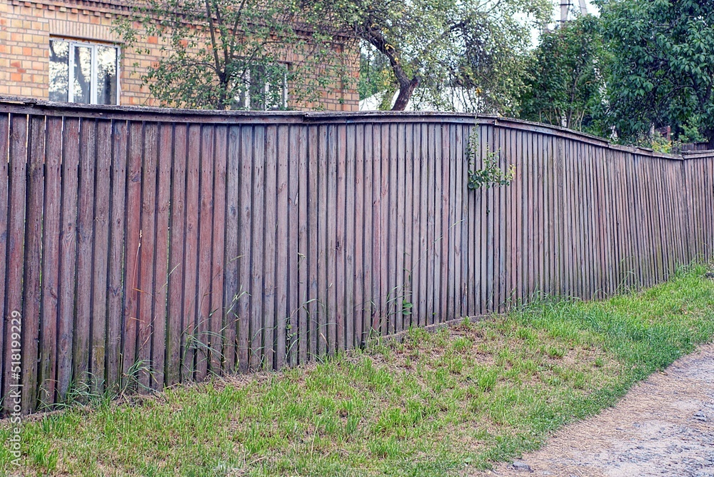 old long brown gray wooden wall fence from boards on the rural street old long brown gray wooden wall fence from boards on the rural street