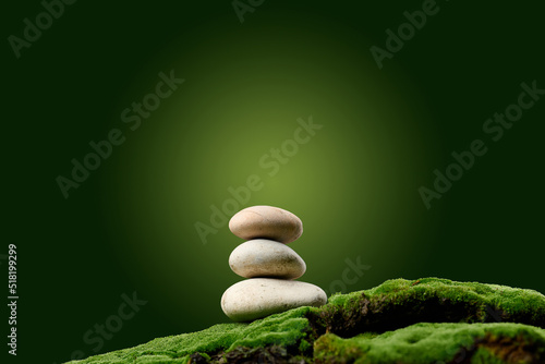 Canvas Print Stack of round stones on green moss, green background