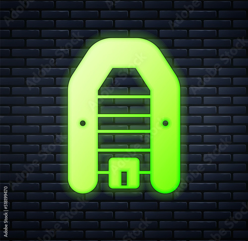 Glowing neon Inflatable boat with outboard motor icon isolated on brick wall background. Vector