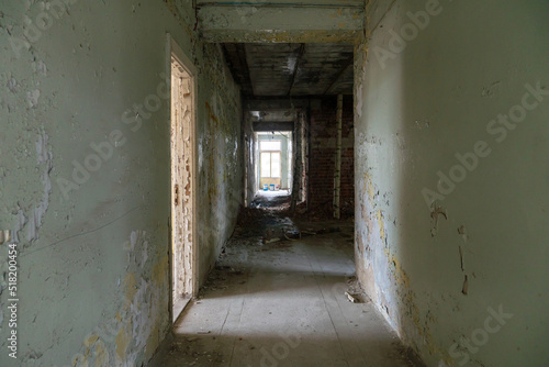 Renovation in the apartment. Destroyed buildings after an earthquake or cataclysm. Walls without plaster and broken red brick. Lack of windows and doors in abandoned apartments. © Pokoman