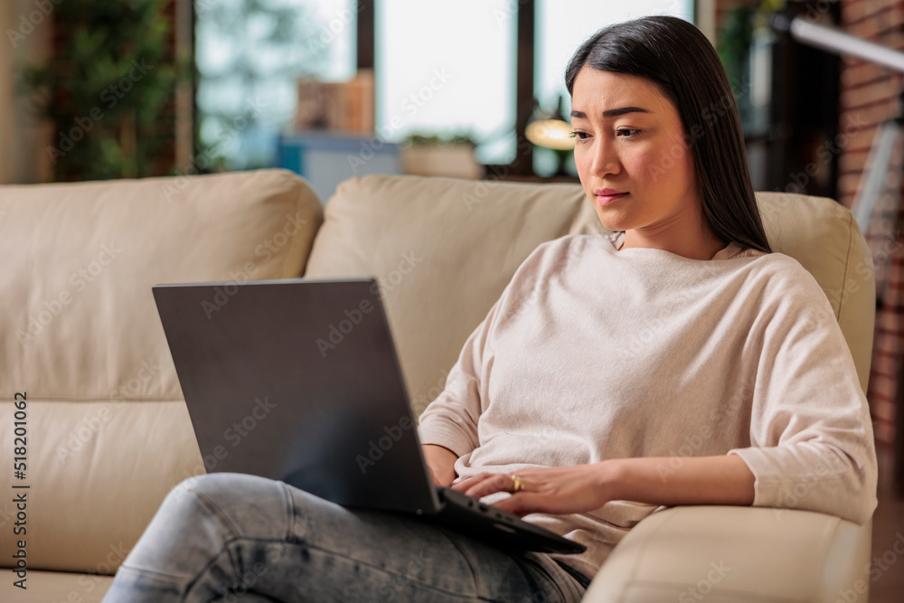 Authentic asian young woman using laptop computer, sitting on couch at home, beautiful girl shopping chatting online on social media, watching movie in leisure time, freelancer working on new project Authentic asian young woman using laptop computer, sitting on couch at home, beautiful girl shopping chatting online on social media, watching movie in leisure time, freelancer working on new project