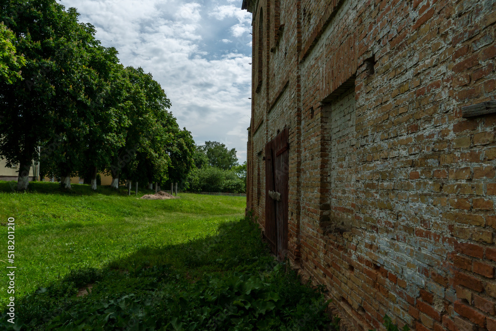 An old brick non-residential building. An ancient historical building. Unusual arched windows and large wooden gates in an ancient synagogue. An old brick non-residential building. An ancient historical building. Unusual arched windows and large wooden gates in an ancient synagogue.