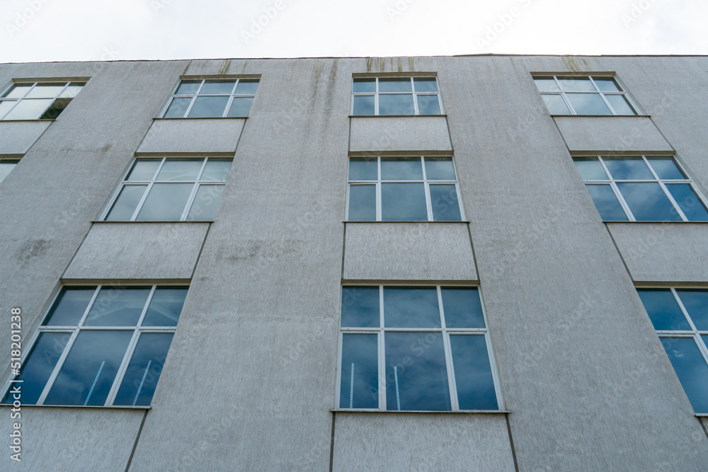View of the facade of an office building with large Windows. New wide double glazed windows installed in a modern building. View of the facade of an office building with large Windows. New wide double glazed windows installed in a modern building.
