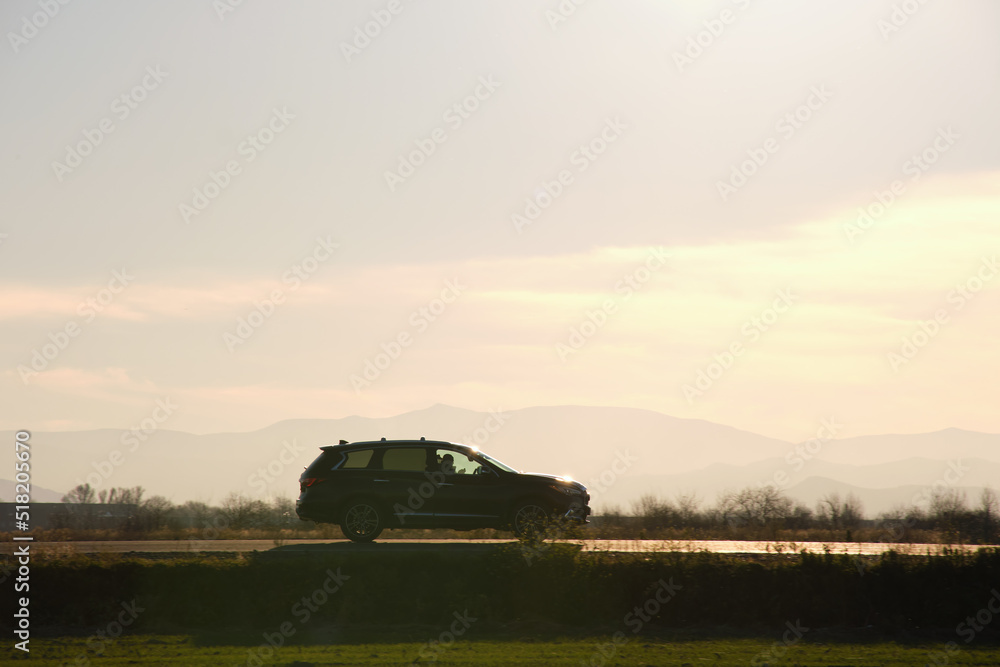 Car driving fast on intercity road at sunset. Highway traffic in evening Car driving fast on intercity road at sunset. Highway traffic in evening