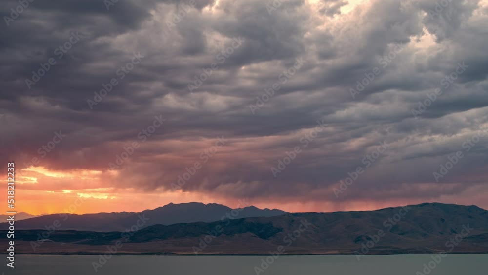 Timelapse of sunset glowing behind dark clouds as storm moves in. Timelapse of sunset glowing behind dark clouds as storm moves in.