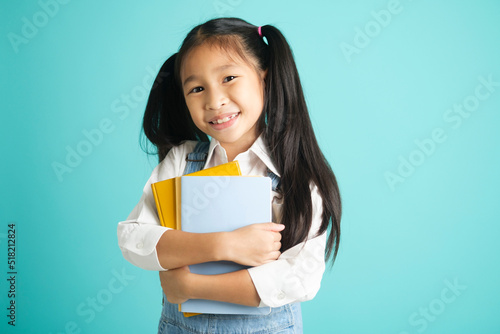 Close-up kid students girl smiling holding book, going to school.