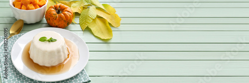 Tasty pumpkin pudding on green wooden background with space for text