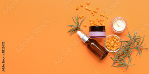 Healthy sea buckthorn cosmetics on orange background with space for text photo