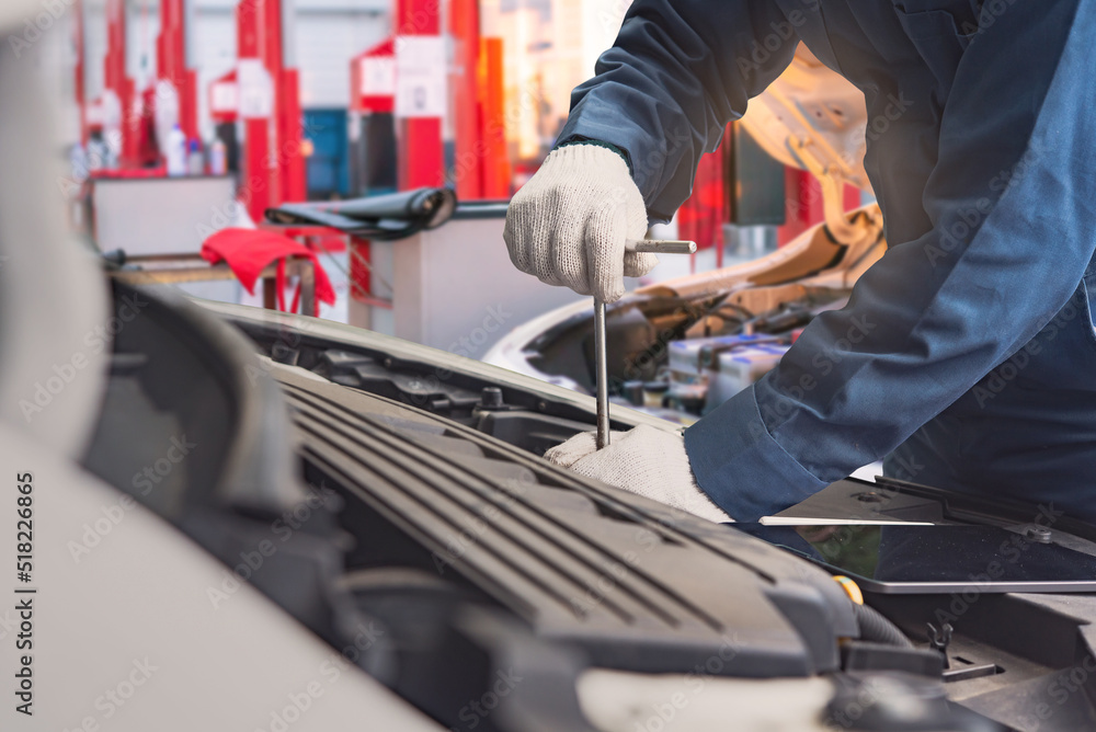 Auto mechanic working in garage. Repair service.  Automobile mechanic repairman hands repairing a car engine automotive workshop with a wrench, car service and maintenance.