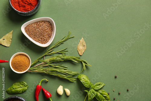 Fototapeta Naklejka Na Ścianę i Meble -  Bowls with spices and herbs on green background