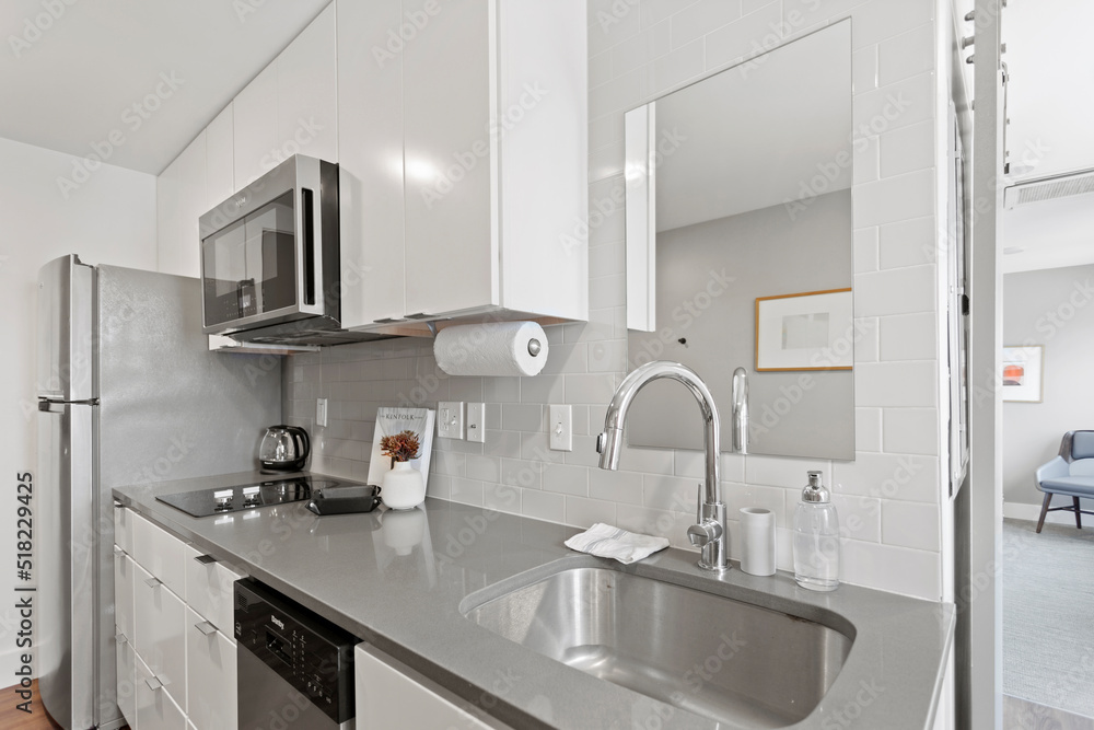 White apartment with wide open spaces, hardwood flooring and modern furniture. Used as a short term rental. White apartment with wide open spaces, hardwood flooring and modern furniture. Used as a short term rental.