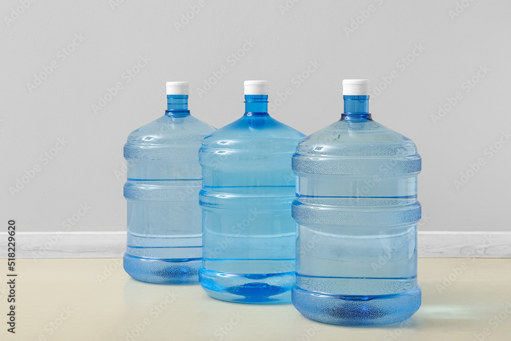 Bottles of clean water on floor near light wall Bottles of clean water on floor near light wall