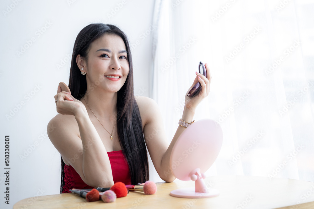 Beautiful asian woman with makeup brushes near face and look mirror, Asian beauty make up, Asian pretty girl holding make up brushes and make up on face with cosmetics set at home facial beauty. Beautiful asian woman with makeup brushes near face and look mirror, Asian beauty make up, Asian pretty girl holding make up brushes and make up on face with cosmetics set at home facial beauty.