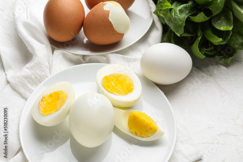 Plates with boiled chicken eggs on light background, closeup