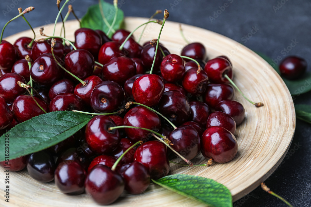 Plate with ripe cherries on table, closeup