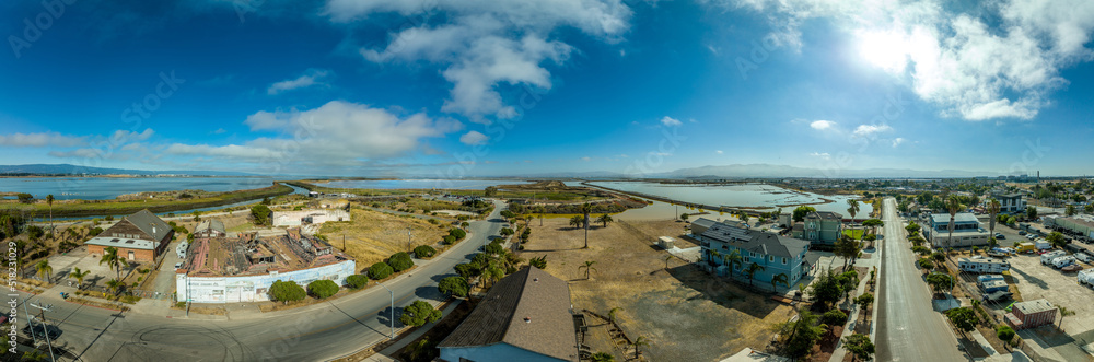 Aerial panorama view of Alviso district in San Jose California with rundown buildings colorful orange, yellow salt marshes in the Bay Area