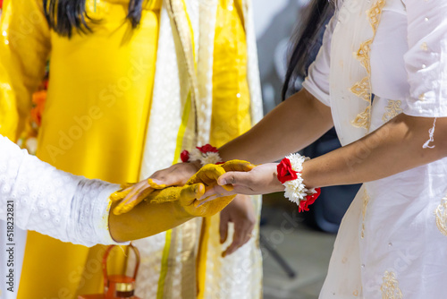 Indian pre wedding haldi turmeric ceremony groom's hands close uup