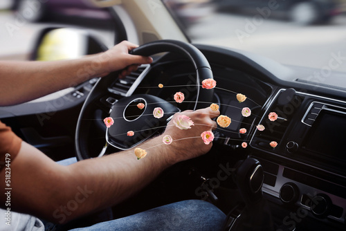 Man enjoying driving car feeling flower scent from ventilation, closeup. Air freshener photo