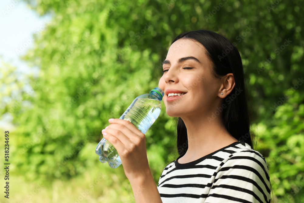 Young woman drinking water outdoors. Refreshing drink Young woman drinking water outdoors. Refreshing drink