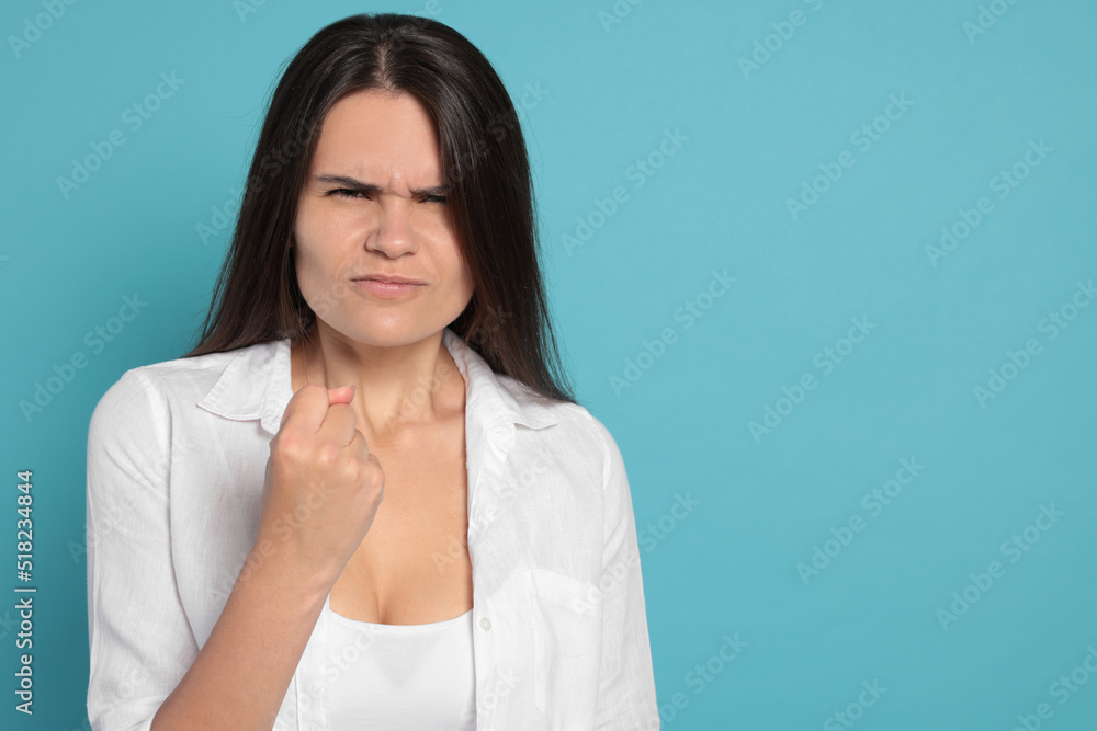Obraz premium Aggressive young woman on turquoise background, space for text