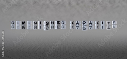 diminished capacity word or concept represented by black and white letter cubes on a grey horizon background stretching to infinity
