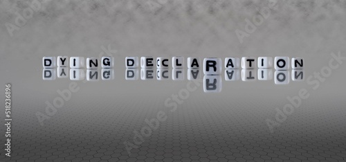 dying declaration word or concept represented by black and white letter cubes on a grey horizon background stretching to infinity photo