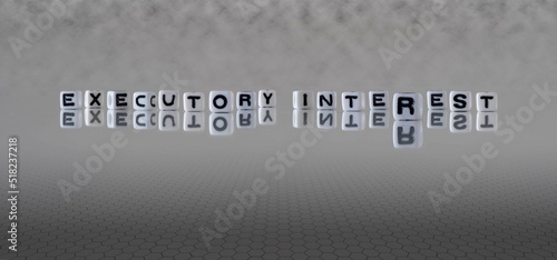 executory interest word or concept represented by black and white letter cubes on a grey horizon background stretching to infinity