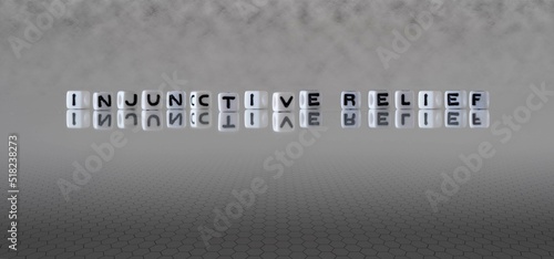 injunctive relief word or concept represented by black and white letter cubes on a grey horizon background stretching to infinity photo