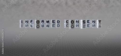 informed consent word or concept represented by black and white letter cubes on a grey horizon background stretching to infinity