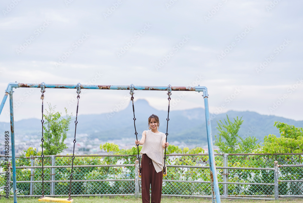 Fototapeta premium 公園でブランコをする女性