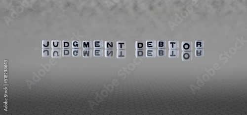 Photo judgment debtor word or concept represented by black and white letter cubes on a