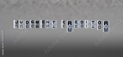 judgment creditor word or concept represented by black and white letter cubes on a grey horizon background stretching to infinity