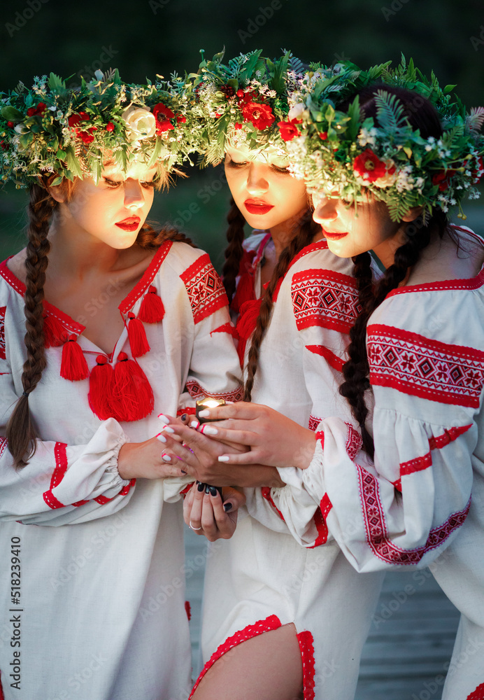 Obraz premium Young pagan girls with a lantern in their hands near the lake in the evening. 