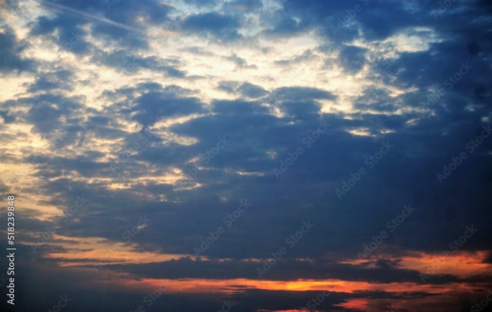 Roter Sonnenuntergang am blauen Himmel mit weißem Wolkengebilde am Abend im Sommer
