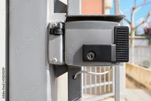 Stainless electromechanical lock outdoors on sunny day photo