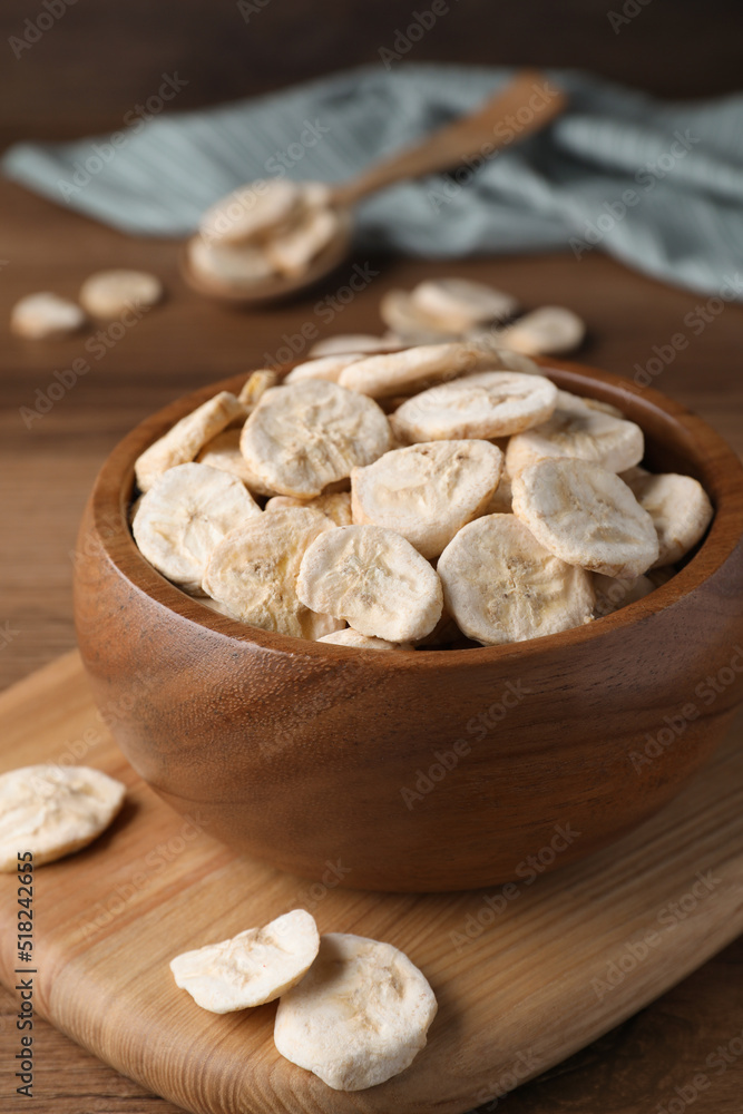 Bowl with dried banana slices on wooden table, closeup Bowl with dried banana slices on wooden table, closeup