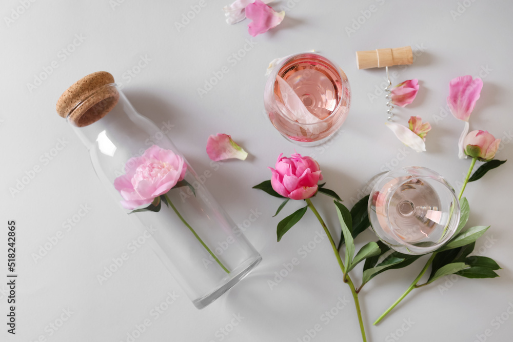 Flat lay composition with rose wine and beautiful pink peonies on white background
