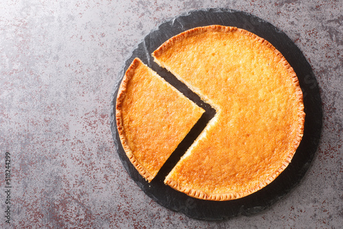 Homemade delicious dessert buttermilk pie in a slate plate on the table. Horizontal top view from above photo