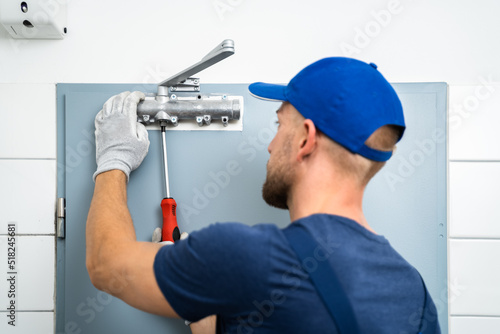 Handyman Installing And Fixing Automatic Door Closer photo