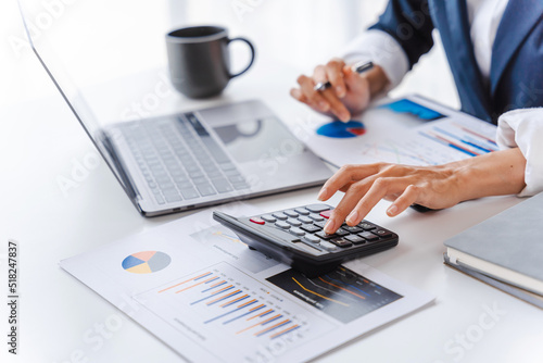 Close up accountant business woman using laptop at workplace with financial reports.