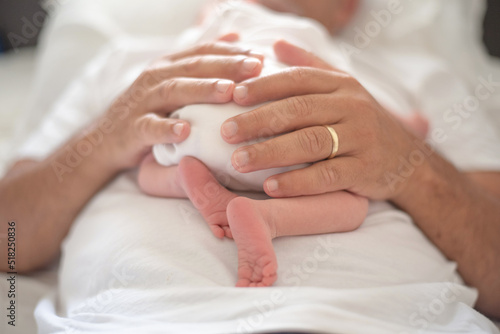 Close up man's strong hands gently holds baby. Newborn sleeping soundly and peacefully on man belly. Birth kid - happiness for family. New worries and style life. Concept of child care, parent love.