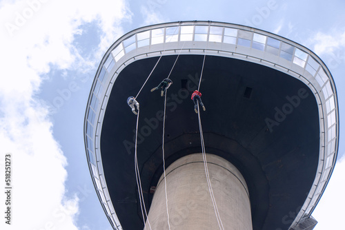 Three young People abseiling down the Eromast tower in Rotterdam photo